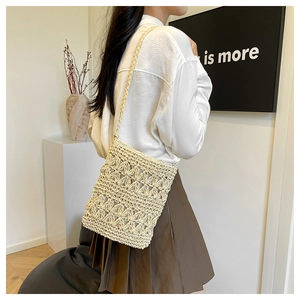 Detail of the woven shoulder bag showing intricate hollow crochet texture and strap