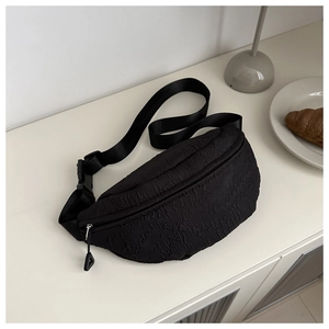 Detail of black textured bubble fabric crescent fanny pack with adjustable strap