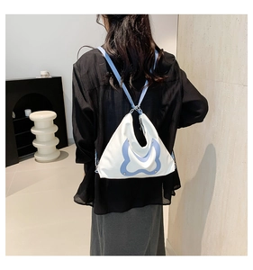 Minimalistische weiß-blaue Tasche mit Schleifenform als Rucksack auf dem Rücken
