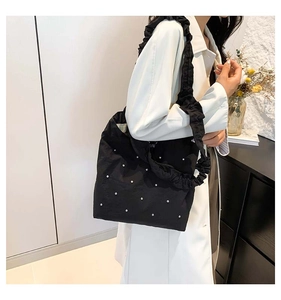 Detail of black rhinestone tote bag featuring a trendy ruffled ruched shoulder strap