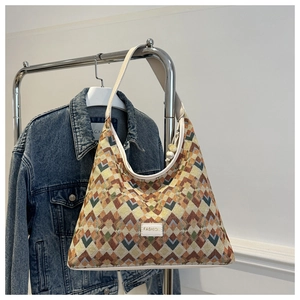 Detail of hobo bag showing geometric wave jacquard fabric and white FASHION label
