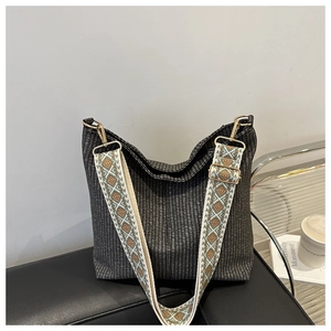 Detail of grey woven bucket bag with vibrant bohemian patterned wide shoulder strap