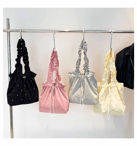 Detail of beaded star drawstring tote bags with ruched handles in four assorted colors
