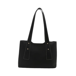 Minimalist black leather tote bag with gold rivets and white contrast stitching details