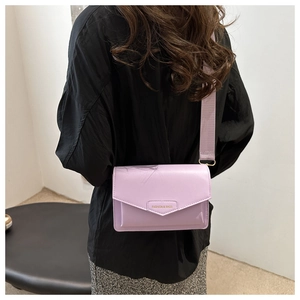 Detail of light purple square crossbody bag with wide strap and fashion lettering