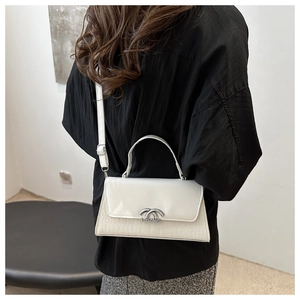Detailed back view of a white crossbody bag featuring elegant crocodile pattern and silver buckle