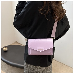 Close-up of light purple PU leather crossbody bag with a wide fabric shoulder strap