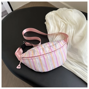 Détail du sac banane rayé coloré montrant le tissu en toile et la sangle rose ajustable