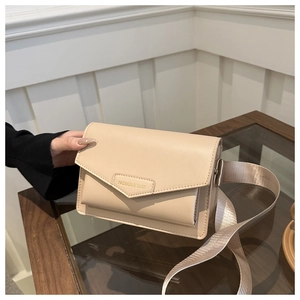 Detail of beige flap crossbody bag with 'FASHION & BAGS' text and wide nylon strap
