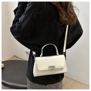 Model wearing white faux leather crossbody bag with crocodile texture side detail