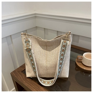 Detailed texture of beige woven tote bag with vintage geometric pattern wide strap