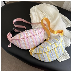 Détail de sacs bananes rayés colorés avec sangles réglables sur un fond noir élégant