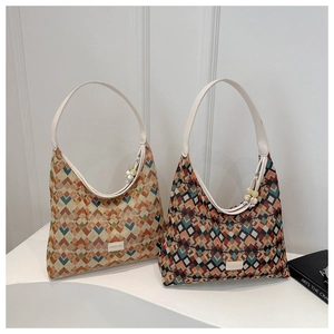 Detail of patterned nylon tote bag with leather strap and decorative bead tassel