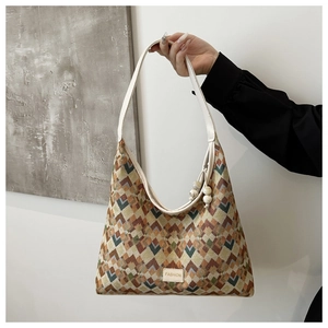 Close-up of geometric jacquard pattern on hobo bag with FASHION leather tag and beaded detail