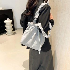 Light gray balletcore tote bag with rhinestones and ruffled bubble strap on a model