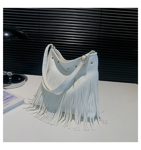 Detail of white pebbled leather hobo bag with long tassels and gold metal hardware