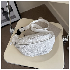 Detail of white bubble texture fabric and black buckle strap on stylish chest bag