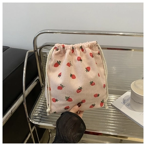 Pochon rose en velours côtelé avec motifs fraises et fermeture par cordon pratique
