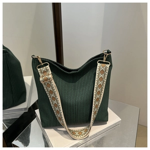 Detail of dark green woven tote bag with geometric pattern wide shoulder strap