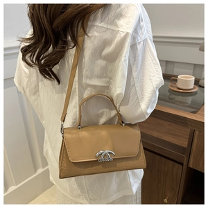 Detail of khaki crocodile embossed shoulder bag with silver dual-ring buckle and logo