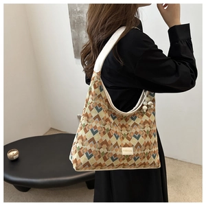 Detail of vintage geometric jacquard hobo bag with white leather strap and pearl pendant