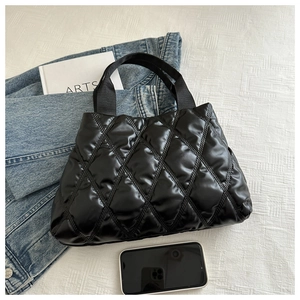 Gros plan sur le sac fourre-tout matelassé noir en nylon imperméable avec texture duveteuse