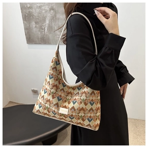 Detail of colorful geometric woven tote bag with Fashion label and cream shoulder strap