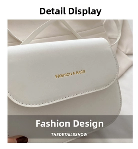 Close-up of white crossbody bag featuring gold 'FASHION & BAGS' text and leather texture