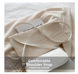 Detail view of smooth white leather shoulder strap with polished gold metal hardware buckle