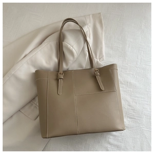 Détail du sac fourre-tout kaki avec surpiqûres blanches et boucle en métal doré