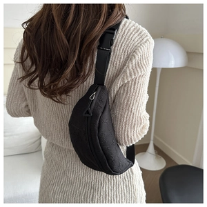 Detail of black bubble textured crescent waist bag with adjustable strap on model