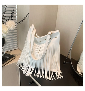 Detailed close-up of white fringe hobo bag with pebble leather texture and gold hardware