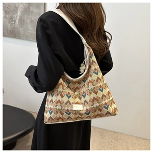 Detail of colorful zigzag woven hobo bag featuring fashion patch and pearl pendant charm