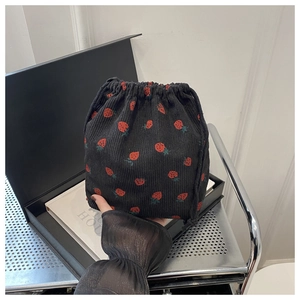 Détail du sac à cordon en velours côtelé avec motif fraises et texture de tissu doux