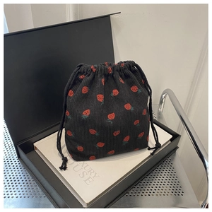 Gros plan d'un sac à cordon en velours côtelé noir avec imprimé fraise rouge vif