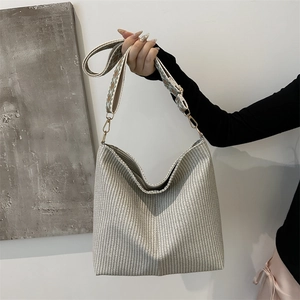 Minimalist woven bucket bag with patterned shoulder strap in cream and grey colors