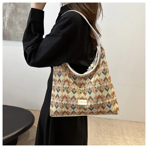 Detail of colorful geometric woven tote with FASHION label and leather strap