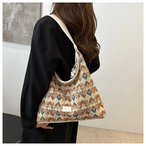 Detail of jacquard weave tote bag with geometric patterns and pearl charm accessory