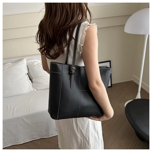 Vue détaillée d'un sac cabas noir avec surpiqûres contrastées blanches en décor minimaliste