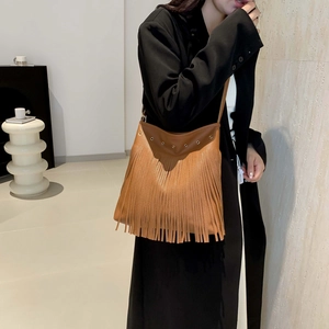 Retro brown tassel hobo bag with pebble leather texture and metal eyelets on model