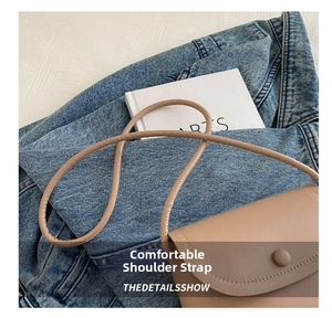 Detail of minimalist beige leather crossbody bag featuring a smooth matte finish and strap