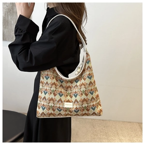 Close-up of geometric jacquard fabric and white leather strap on a fashion tote bag