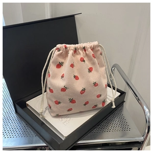 Détail du sac à cordon en velours rose avec motif fraise pour le rangement pratique