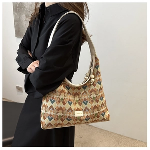 Detailed view of geometric patterned nylon tote bag with leather strap and fashion plaque