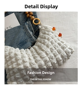 Détail du tissu blanc plissé avec des perles en bois et des perles oranges