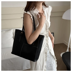 Détail d'un sac cabas en cuir noir avec surpiqûres blanches et intérieur spacieux