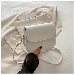 Detail of white leather shoulder bag with gold 'FASHION & BAGS' lettering and strap