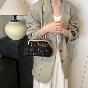 Elegante borsa in pelle lucida nera con borchie a cuore dorate e chiusura a scatto
