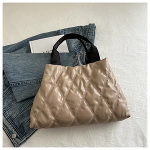 Sac à main matelassé marron avec larges anses noires sur veste en jean