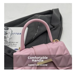 Détail du sac à main matelassé rose avec poignée arrondie et fermoir en métal doré
